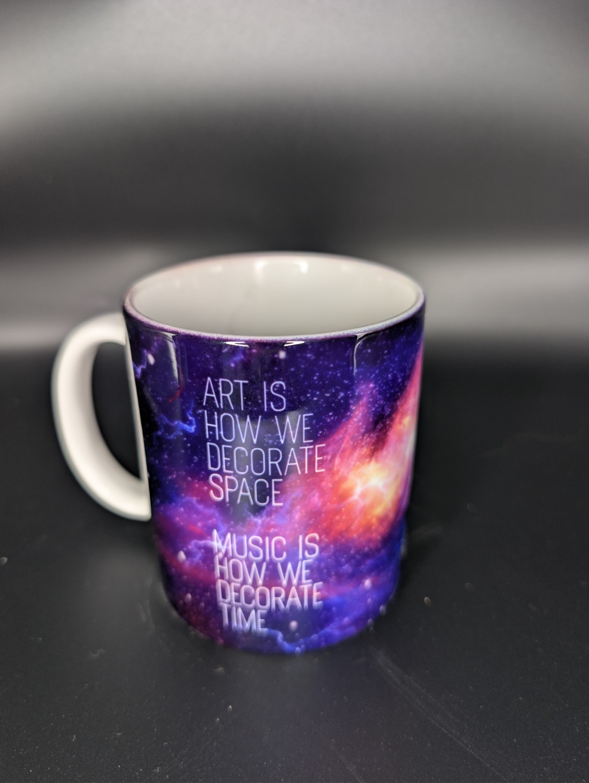 Reverse of a colourful galaxy mug with art and music quotation