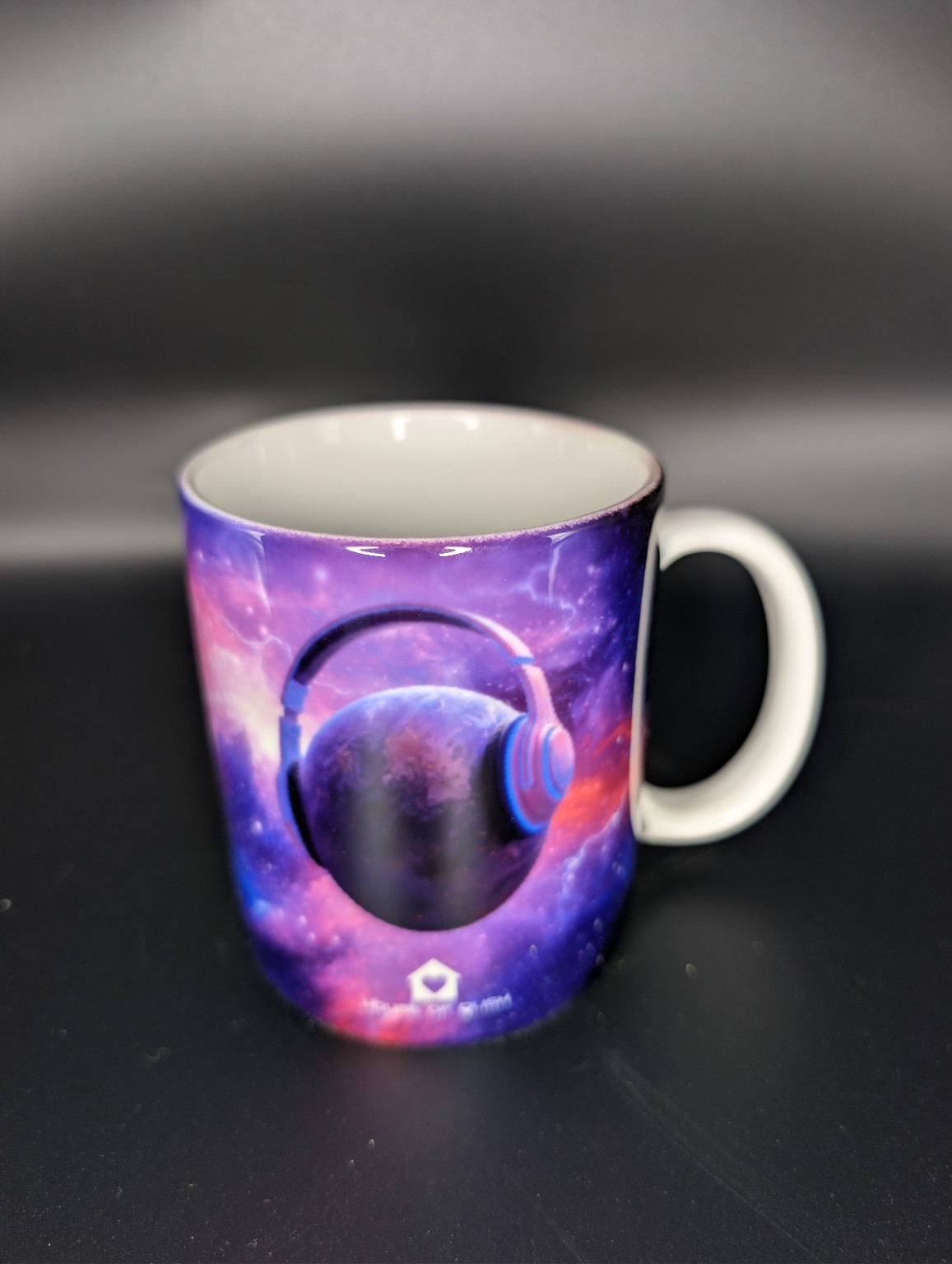 Colourful galaxy mug featuring headphones around a planet