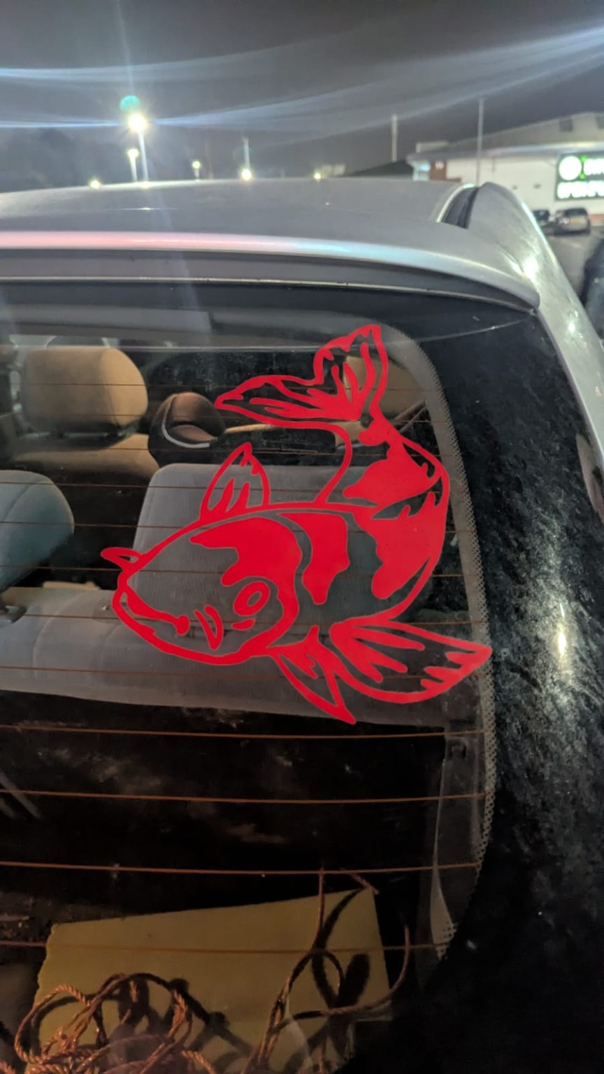 Red and grey koi decal on a vehicle rear window
